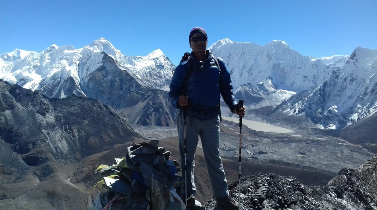 Govinda Prasad Sapkota standing at the summit of Chukhung Ri, overlooking Chukhung Valley in the Everest region