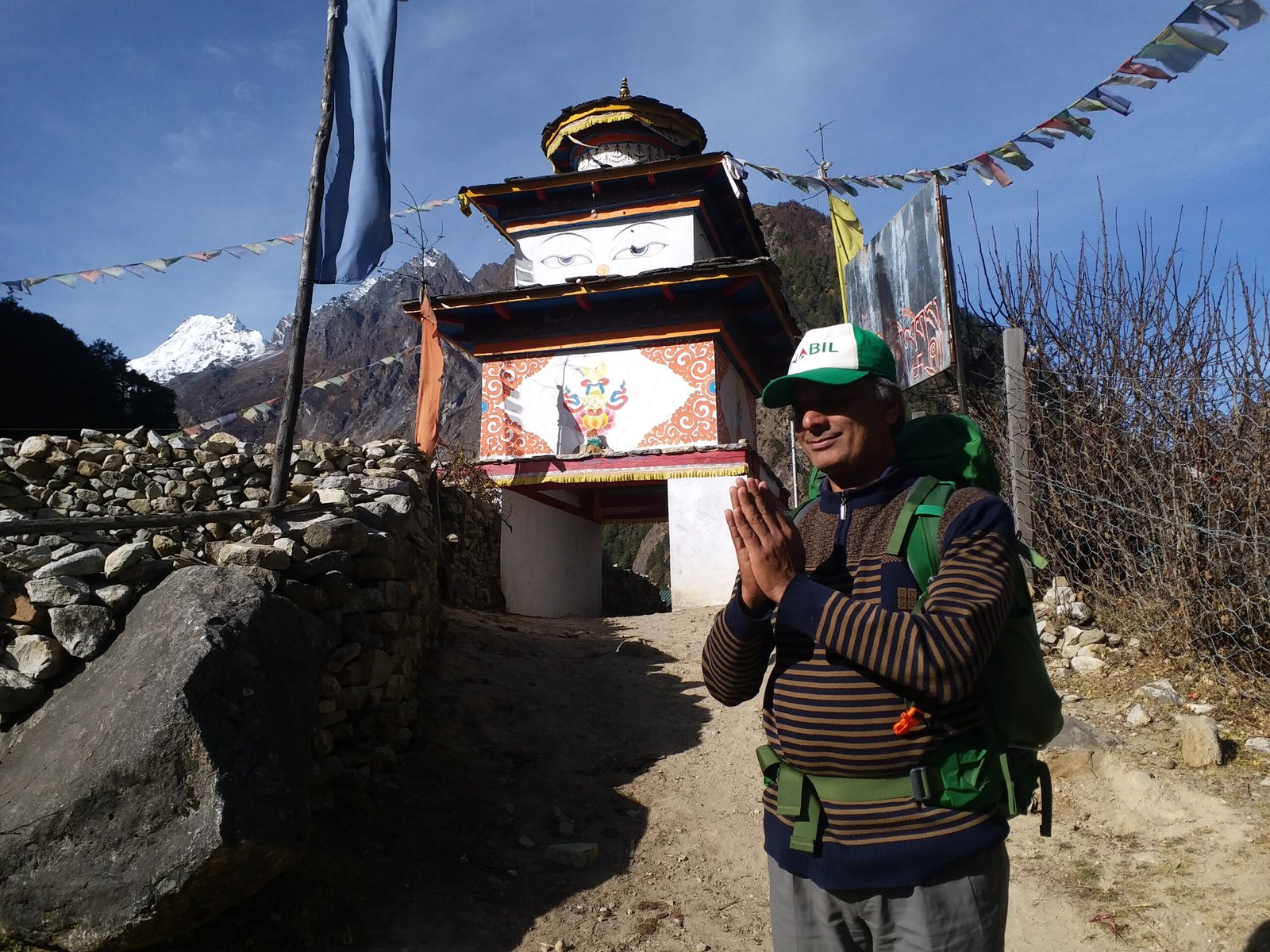 Govinda Prasad Sapkota performing Namaste in front of a traditional chorten at Syala in the Manaslu region of Nepal